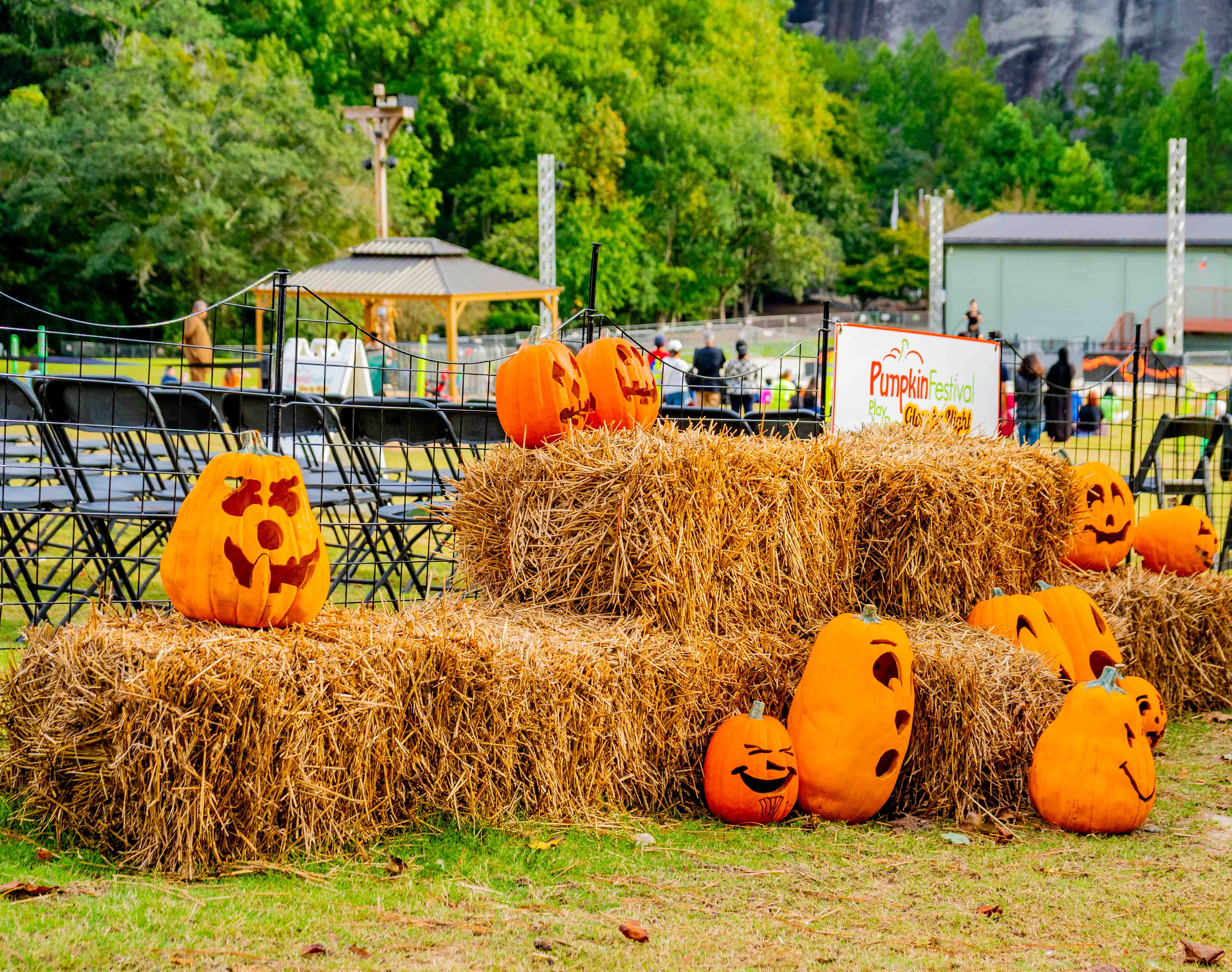 Carved pumpkins and hay bales at an outdoor fall festival